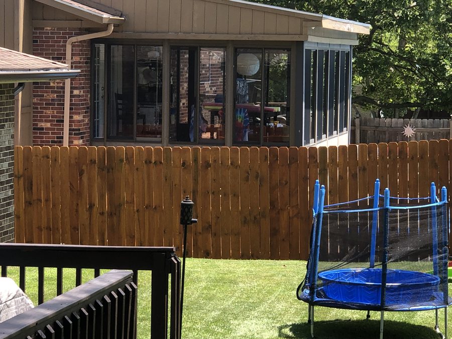 Stained cedar wood privacy fence in residential backyard by Broadway Fence LLC