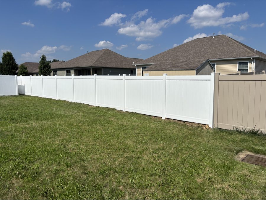White vinyl privacy fence with tan accent section in suburban Dayton yard