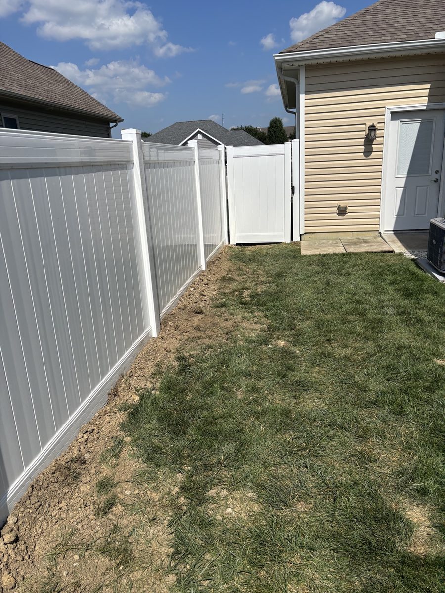 White vinyl privacy fence with matching gate installed beside Dayton home